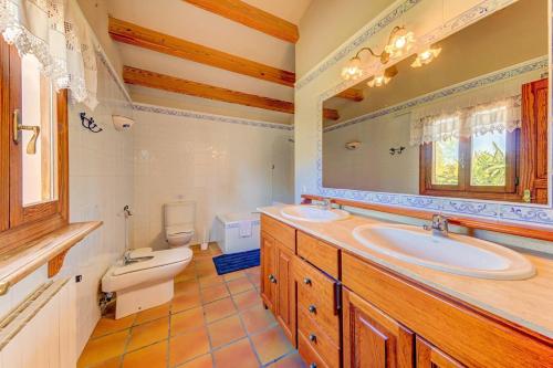 een badkamer met 2 wastafels en een toilet bij Lovely Alcudia Villa Casa De Arcos Private Pool Gardens Close to Resort Centre and Beaches in Alcudia