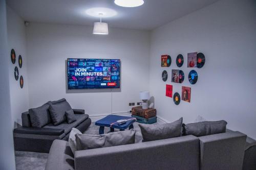 ein Wohnzimmer mit 2 Sofas und einem Gemälde an der Wand in der Unterkunft BV Classic 3 Bedrooms At Cliff Oak Leeds Perfect For Contractors in Leeds