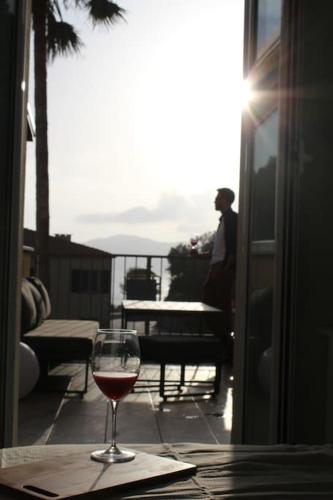 a glass of wine sitting on top of a table at Appartamento romantico con piscina in Cervo