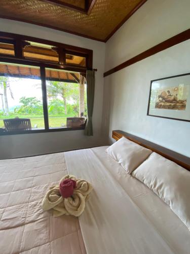 a bedroom with a white bed with a flower on it at Geriasemalung in Tirtagangga