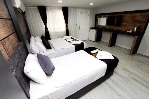 een hotelkamer met 2 bedden en een keuken bij MİLA SUİTES TAKSİM in Istanbul