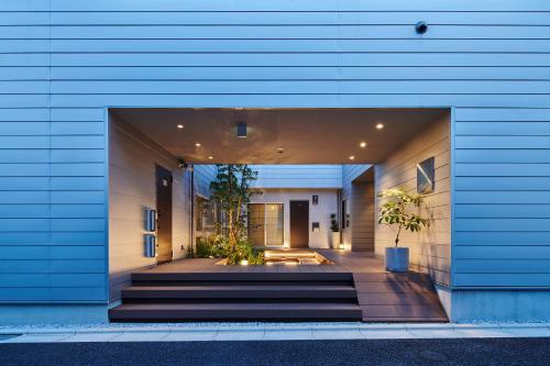 a blue building with stairs and plants in it at Reikyo Garden Osaka in Osaka
