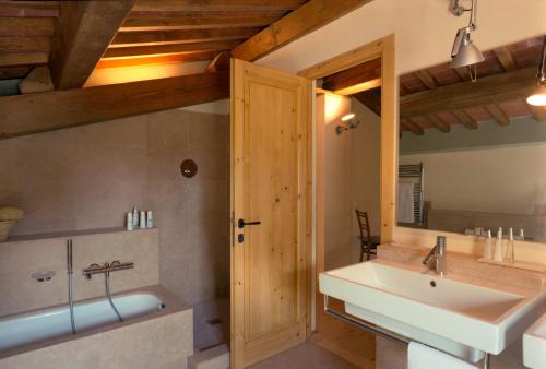 een badkamer met een bad, een wastafel en een bad bij Fattoria Casamora - Villa Le Magnolie in Pian di Scò