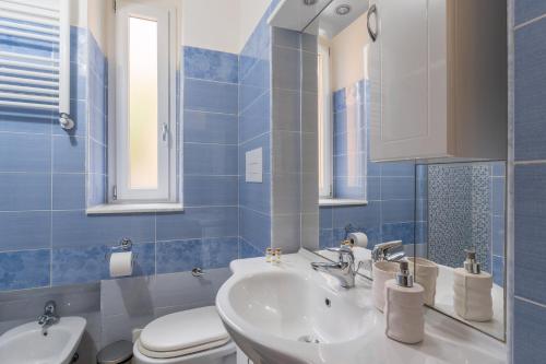 baño de azulejos azules con lavabo y aseo en Seaside apartament near the Beach, en Minturno