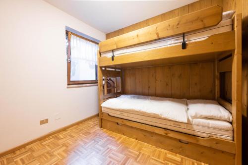 a bedroom with two bunk beds and a wooden floor at Cesa te Val in Vigo di Fassa