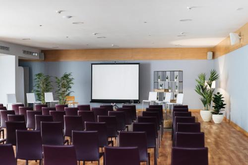 a conference room with chairs and a projection screen at Reverence Mare Hotel - Adults Only in Palmanova