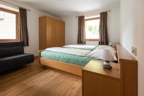 1 dormitorio con cama, escritorio y silla en Pixnerhof - Ferienwohnung Gala, en Ciardes