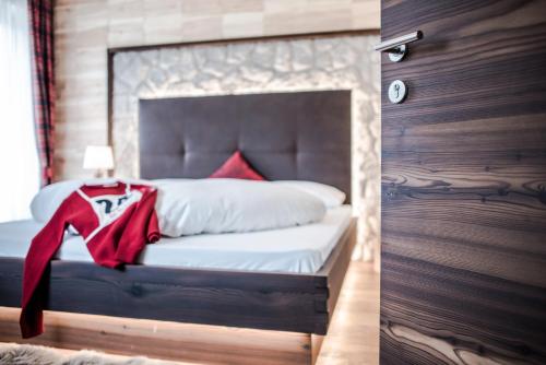 a bedroom with a bed with a red cape on it at Garni Residence Soraiser in Selva di Val Gardena