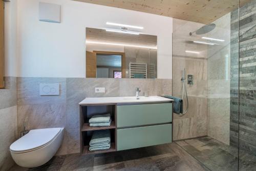 een badkamer met een wastafel, een toilet en een douche bij Pixnerhof Chalet Natyra in Ciardes