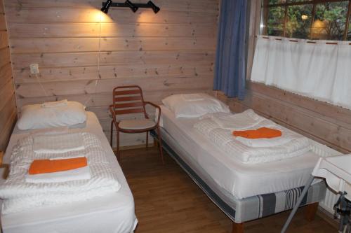Habitación con 2 camas y una silla. en Chalet Nieuw Beusink, en Winterswijk