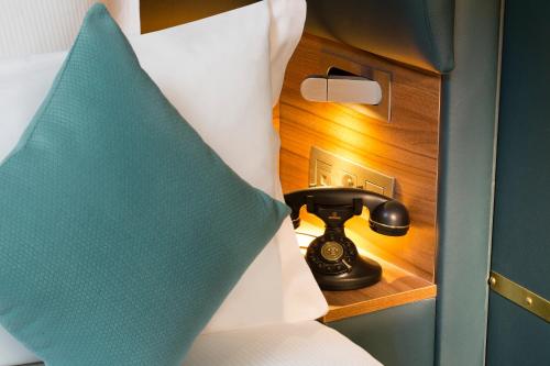 a telephone in a room with a bed at Hotel Whistler in Paris