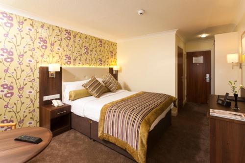 a hotel room with a bed and a table at Best Western Plus White Horse Hotel in Derry Londonderry
