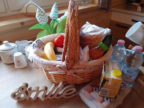 a basket of fruit and vegetables on a table at Apartament z Tężnią Solankową, Sauną, Kominkiem LED i Śniadaniem nad Jeziorem Żywieckim in Zarzecze