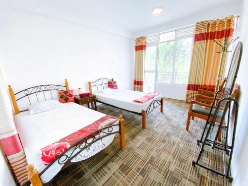 a bedroom with two beds and a window at Berghaus Bungalow in Ella