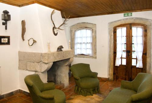 a living room with two chairs and a fireplace at Quinta do Brejo - Turismo Equestre in Mafra