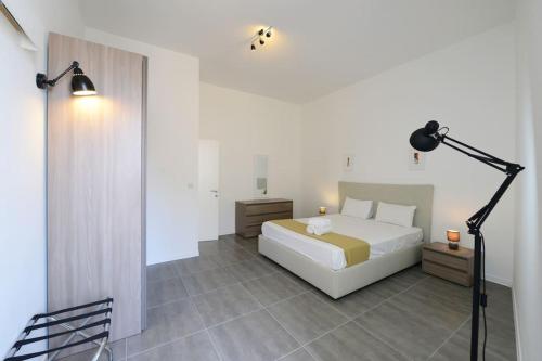 a bedroom with a white bed and a lamp at Harbour Gem Sea View 6 by VallettaStay in Valletta