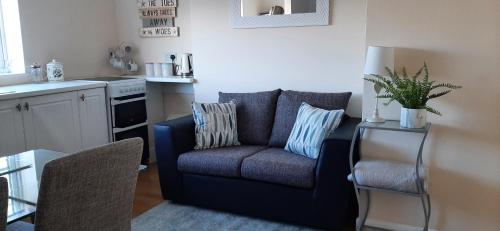 a living room with a blue couch in a kitchen at Estuary view in Exmouth