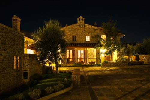 a large stone house at night with lights at Fattoria Casamora - Suites in Pian di Scò