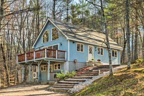a blue house with a deck in the woods at Mountain-View Conway Cabin about 9 Mi to Slopes! in Conway
