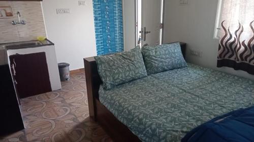 - une chambre avec un lit doté d'oreillers bleus dans l'établissement Harini Nivas, à Kodaikānāl