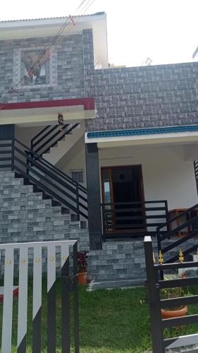 une maison avec des escaliers et une clôture devant elle dans l'établissement Harini Nivas, à Kodaikānāl
