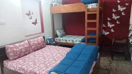 - une chambre avec des lits superposés et une chaise dans l'établissement Harini Nivas, à Kodaikānāl