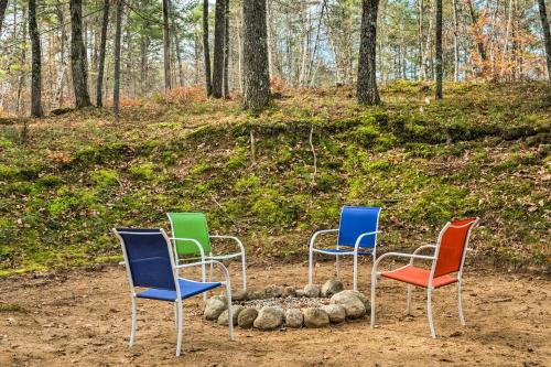 four chairs sitting around a fire in the woods at Mountain-View Conway Cabin about 9 Mi to Slopes! in Conway