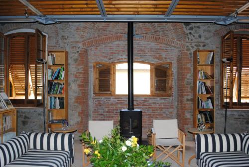 a living room with two chairs and a fire place at Fattoria Casamora - Suites in Pian di Scò