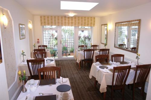 a restaurant with tables and chairs with white tablecloths at Cedar Lodge in Llandudno