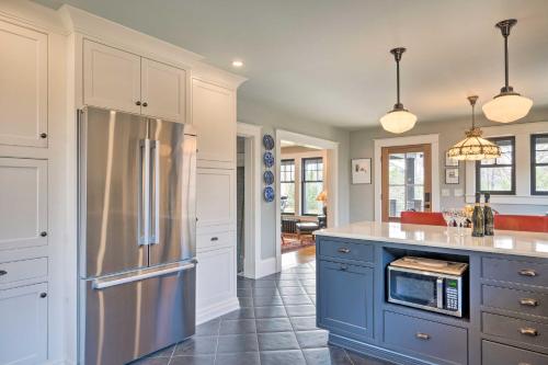 a kitchen with a stainless steel refrigerator and blue cabinets at Upscale Arts and Crafts Bungalow with Yard, Pool! 
