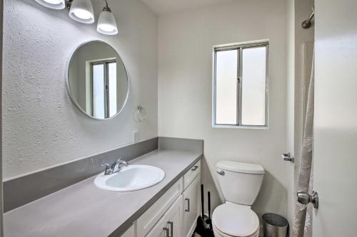 a white bathroom with a sink and a mirror at Comfy Bakersfield Townhome - Fire Pit and Patio in Bakersfield