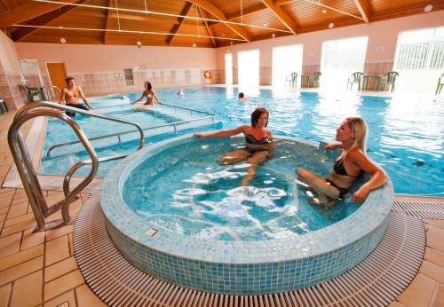 eine Gruppe von Frauen, die in einem Schwimmbad sitzen in der Unterkunft La Villette Hotel in St Martin Guernsey