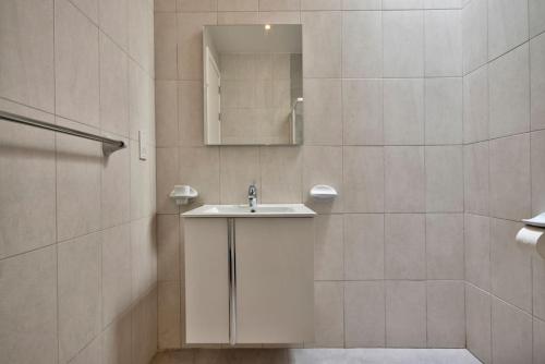 uma casa de banho com um lavatório e um espelho em VALLETTASTAY - HARBOR VIEW GEM -SEA VIEW 2 BED APT em Valletta