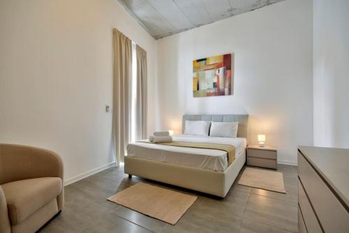 um quarto branco com uma cama e um sofá em VALLETTASTAY - HARBOR VIEW GEM -SEA VIEW 2 BED APT em Valletta