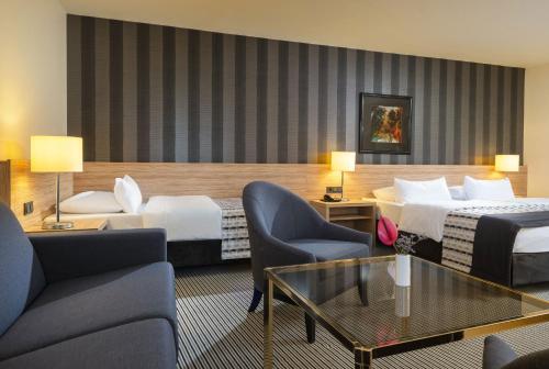 a hotel room with two beds and a table and chairs at Maritim Hotel Königswinter in Königswinter