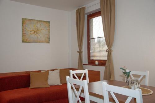 een woonkamer met een bank en een tafel en stoelen bij Chata Soukenná in Dolní Moravice