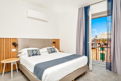 a bedroom with a bed and a large window at Colonna 24 Luxury Room in Portovenere near 5 Terre in Portovenere