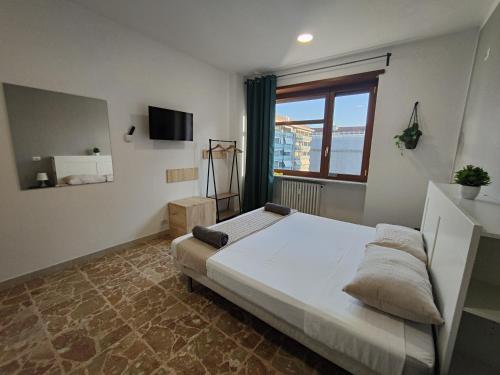 - une chambre avec un grand lit et une fenêtre dans l'établissement Affittacamere - Santa Rita Rooms, à Turin