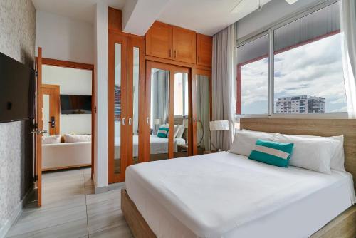 una camera da letto con un grande letto con una grande finestra di Apartamento N1001 Downtown Santo Domingo a Santo Domingo