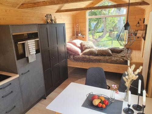 a kitchen with a table with a bowl of fruit on it at Tiny House Flensburg Luv in Jarplund
