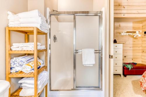 La salle de bains est pourvue d'une douche et de serviettes sur les étagères. dans l'établissement Mules Ear Trail Cabin 8, à Black Butte Ranch