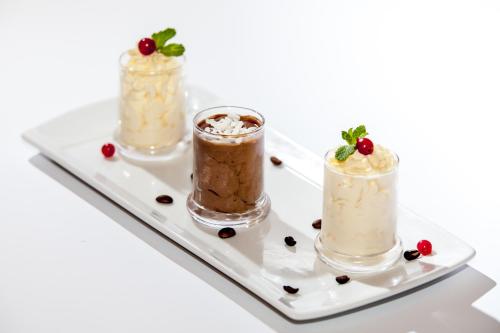 three different desserts on a plate at Crystal Palace Hotel in Bucharest