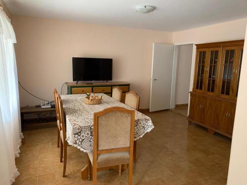 a dining room with a table and a television at AMANECER in Las Grutas