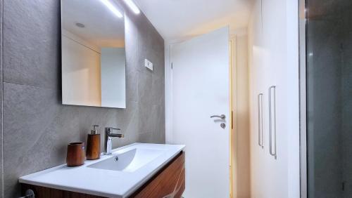 a bathroom with a white sink and a mirror at Sweet Stay Castle Apartment in Ljubljana