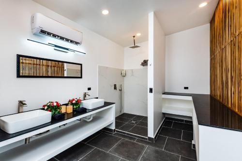 Baño con 2 lavabos y espejo en House of Nomad - Adults only en Tamarindo