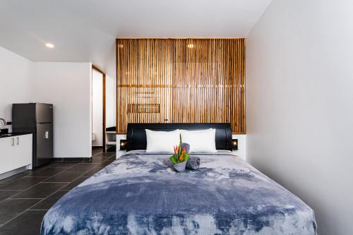 a bedroom with a large bed and a kitchen at House of Nomad - Adults only in Tamarindo