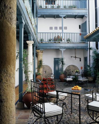 a patio with chairs and tables in a building at Hospes Las Casas del Rey de Baeza, a Member of Design Hotels in Seville