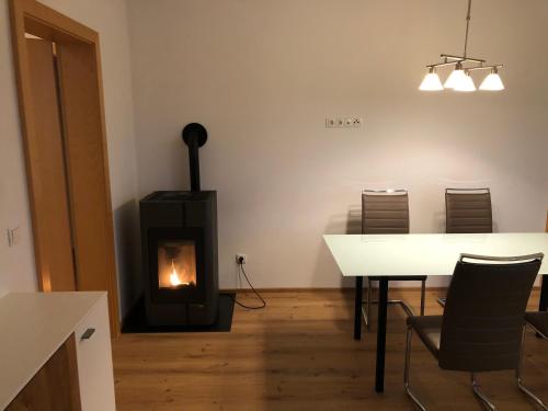 ein Wohnzimmer mit einem Tisch und einem Kamin in der Unterkunft WM-Appartements in Haus im Ennstal