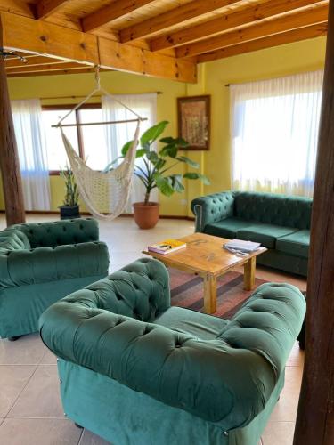 a living room with green couches and a table at Ruca Nel in El Calafate