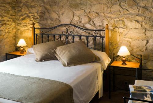 a bedroom with a bed and two lamps on tables at Casa Rural El Pati de l´Albera in Sant Climent Sescebes